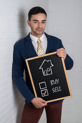 Man in a suit with a black board in his hands on a white backgro