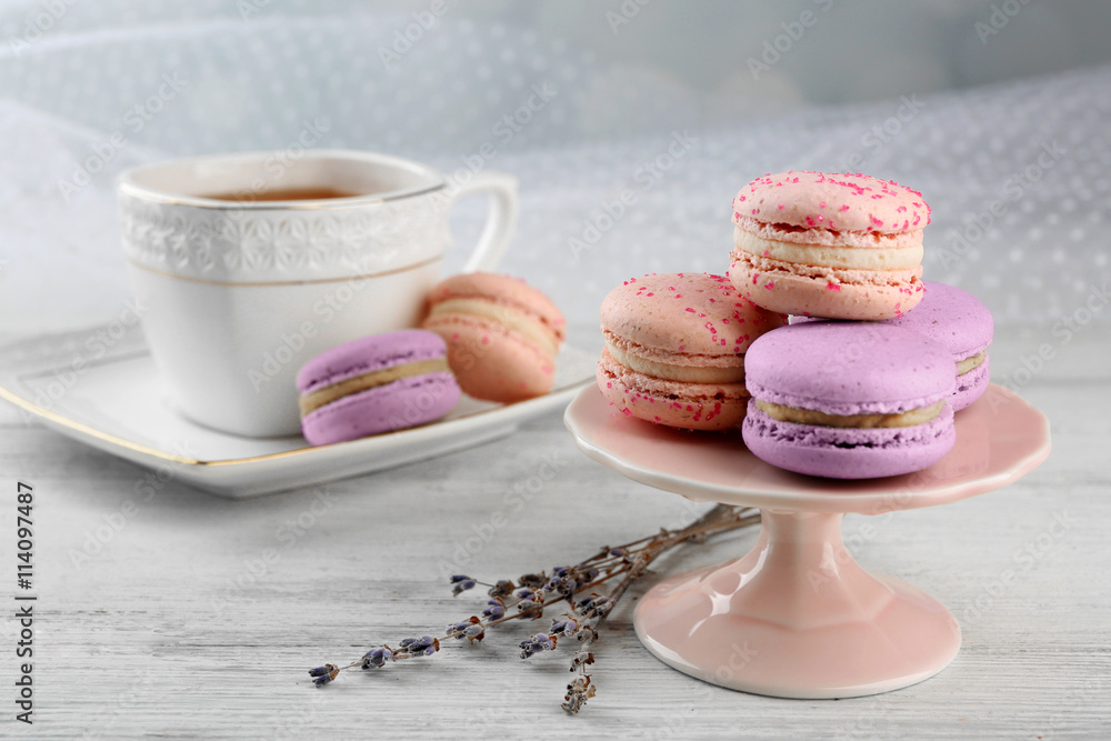 Tasty macaroons with tea on wooden table