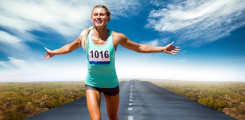 Wall Mural - Composite image of sportswoman finishing her run