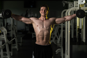  Young Man With Dumbbells Exercising Shoulders