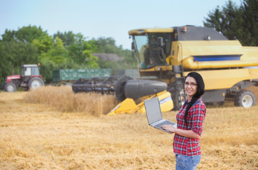 Wall Mural - Famer girl with laptop in the field