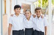© WavebreakMediaMicro - Smiling school kids standing with arm around in corridor