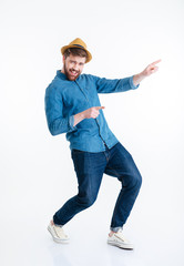 Poster - Cheerful young bearded man dancing over white background