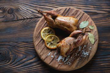 Wall Mural - Serving board with whole baked quails in a rustic wooden setting