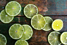 Slices Of Lime On Old Wooden Surface