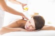 © WavebreakMediaMicro - Masseur pouring massage oil on woman