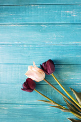 Black tulips on the table. On a wooden background lie two beautiful tulip.