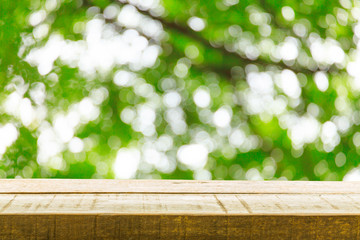 Wood table top on green tree background. fo display or montage products.