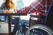 © Wavebreak Media - Midsection of disabled man sitting with woman at cafe