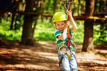 Adventure Climbing High Wire Park - Little Child On Course In Mountain Helmet And Safety Equipment