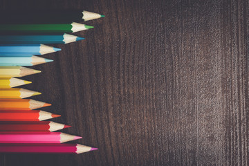 Wall Mural - multicolored pencils on the dark brown wooden table