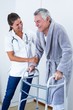 © WavebreakmediaMicro - Female doctor helping senior man to walk with walker