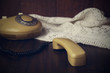toned image of an old-fashioned handset and phone on knitted nap