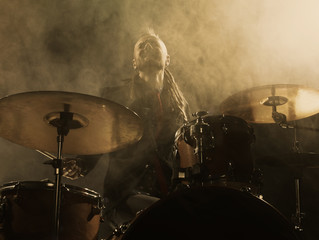 Wall Mural - Silhouette drummer on stage. Dark background, smoke spotlights