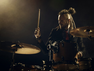 Wall Mural - Silhouette drummer on stage. Dark background, smoke spotlights