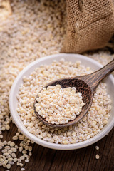 Barley beans in wooden cup. Grains of malt close-up. Barley on w