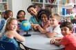 © WavebreakMediaMicro - Female teacher and children with globe on table