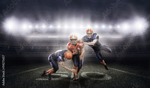 American football players in action on stadium with ball