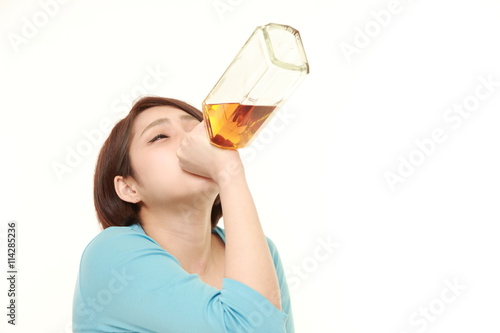 豪快にラッパ飲みをする若い女性 Stock Photo Adobe Stock