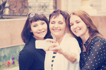 Three mature women friends doing selfie on a mobile phone