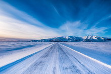 Empty Snow Covered Road In Winter Landscape