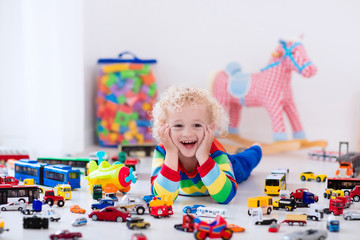 Wall Mural - Little boy playing with toy cars