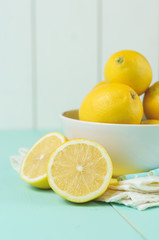 Wall Mural - Fresh lemons in a white bowl on wooden background.Half of lemon.