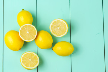 Wall Mural - Lemons scattered on a blue wooden background.