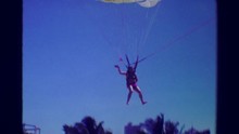 1978: Parasailing Man Parachute Landing On Beach Helped By Staff.