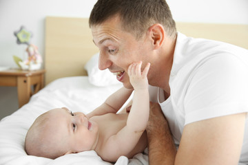 Wall Mural - Father playing with smiling baby