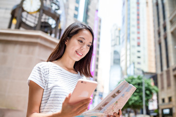 Sticker - Woman looking at city map with mobile phone in Hong Kong city