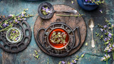 Fototapeta Mapy - Herbal tea setting with cup of herbal tea, herbs and flowers. Vintage tea set on dark rustic background, top view. Healthy ,healing or detox drinks concept