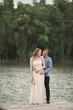 © olegparylyak - Elegant beautiful wedding couple posing near a lake at sunset