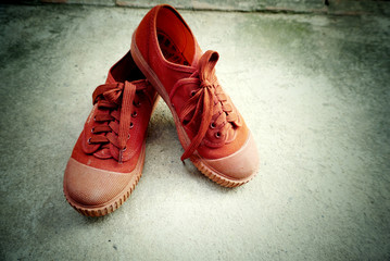 pair of old brown shoes for school on cement background, vintage tone