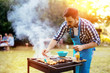 © NDABCREATIVITY - HAndsome male preparing barbecue