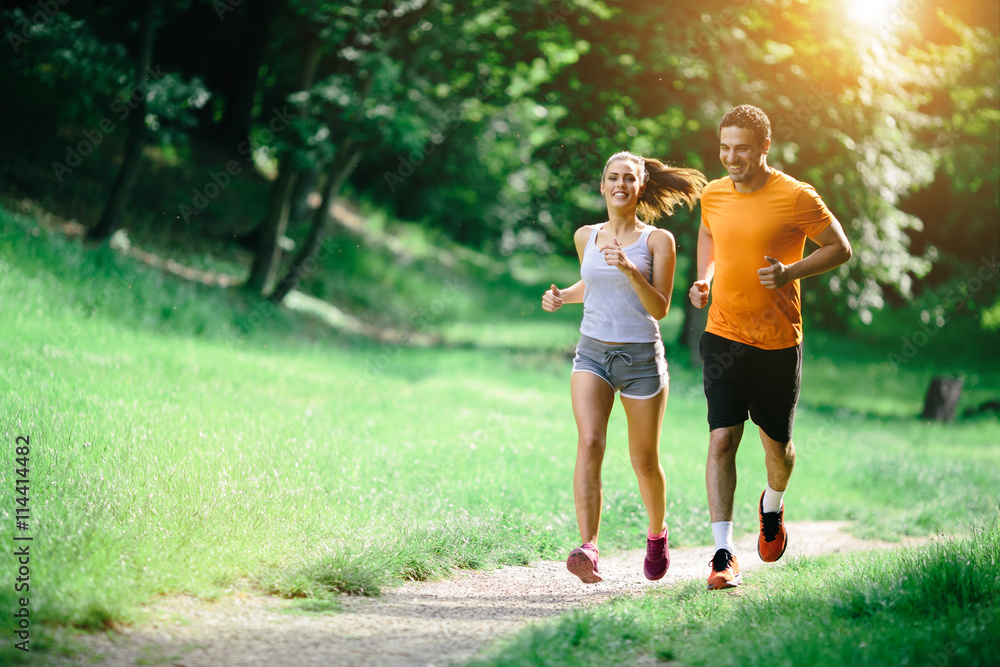 Healthy couple jogging in nature - obrazy, fototapety, plakaty 
