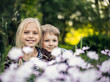 © Una - Beautiful blond girl and adorable boy hiding in flowers