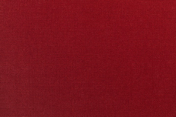 Dark red background from a textile material. Fabric with natural texture. Backdrop.