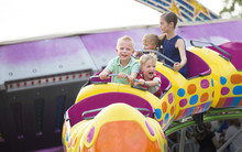 Kids On A Thrilling Roller Coaster Ride At An Amusement Park