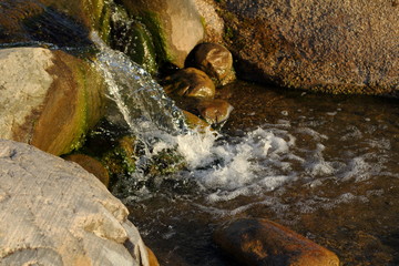 Stones in stream./Stones in stream with smooth flowing water.