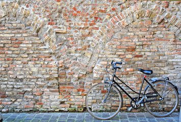 Canvas Print - Ravenna, bicycle parked against an old wall in the city center.