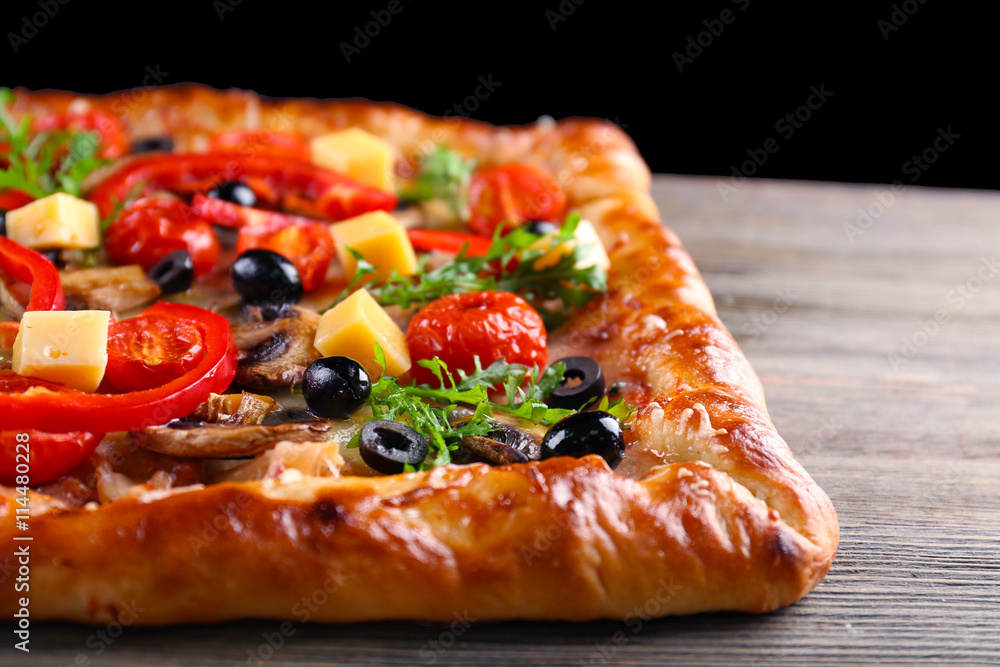 Freshly homemade pizza on wooden table closeup