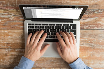 Wall Mural - close up of male hands with laptop typing