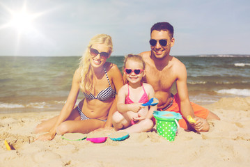 Poster - happy family playing with sand toys on beach