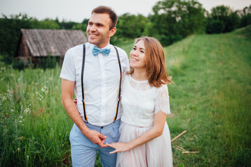 Happy Bride and groom walking on the green grass