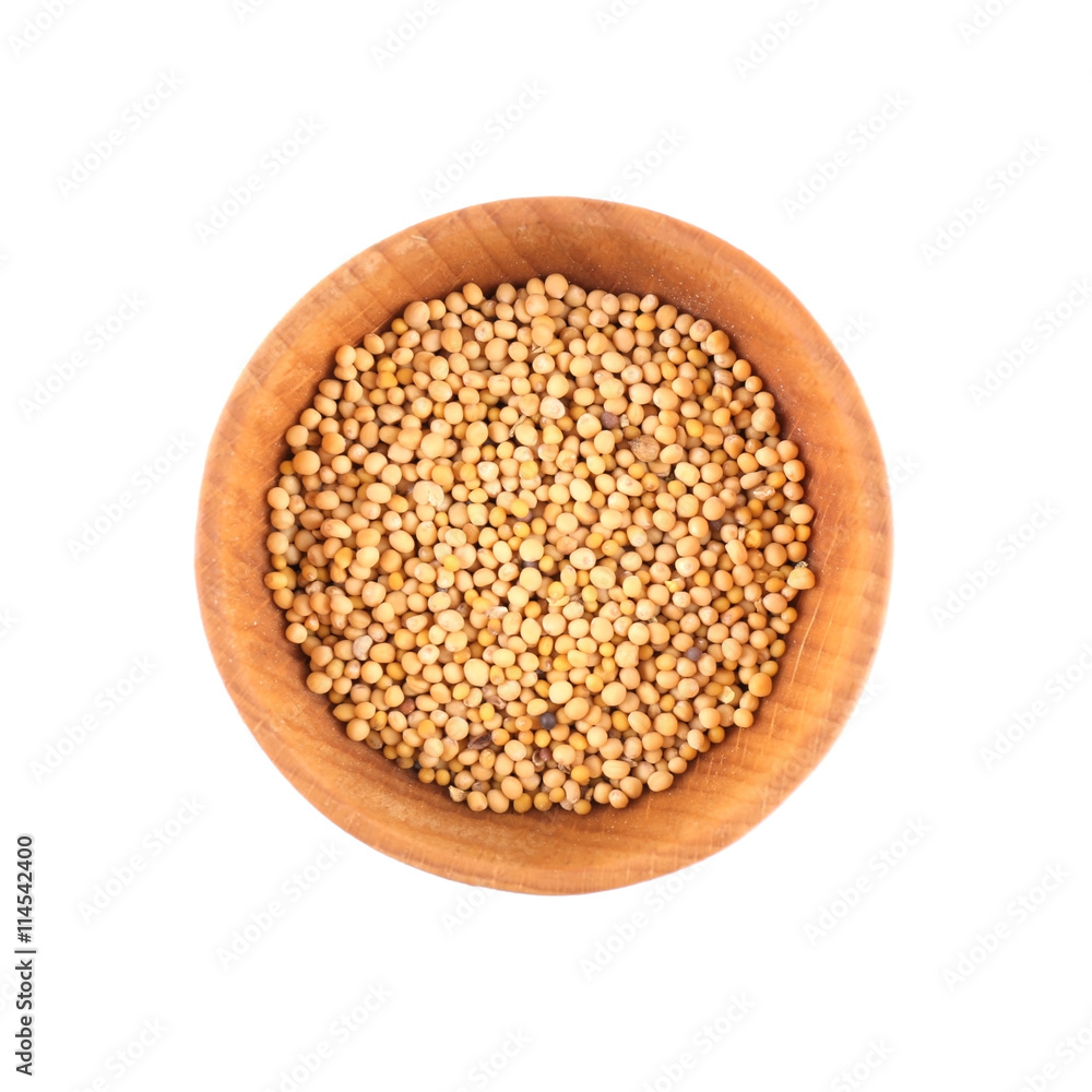Mustard seeds in small wooden bowl isolated on white