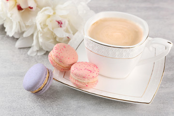 Wall Mural - Cup of coffee with macaroons and peonies on wooden table