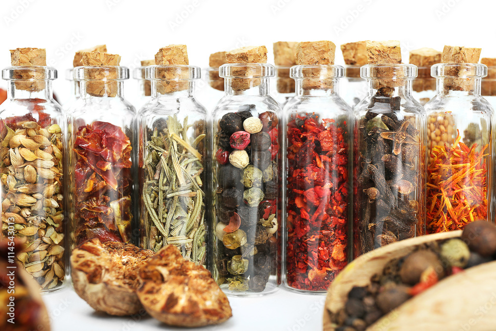 Assorted dry spices in glass bottles, close up