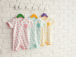 Wall Mural - Colorful set of baby romper on brick wall