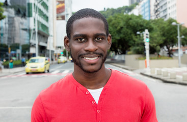 Laughing african american man with red shirt in city